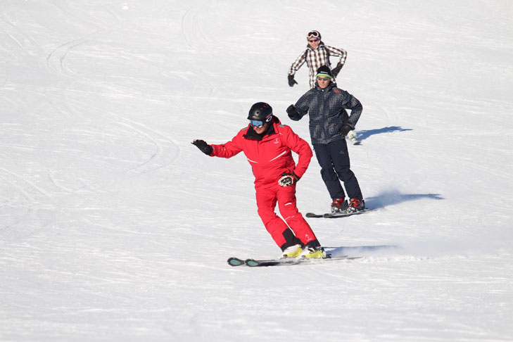 Skileraar leert parallelhouding te skiën
