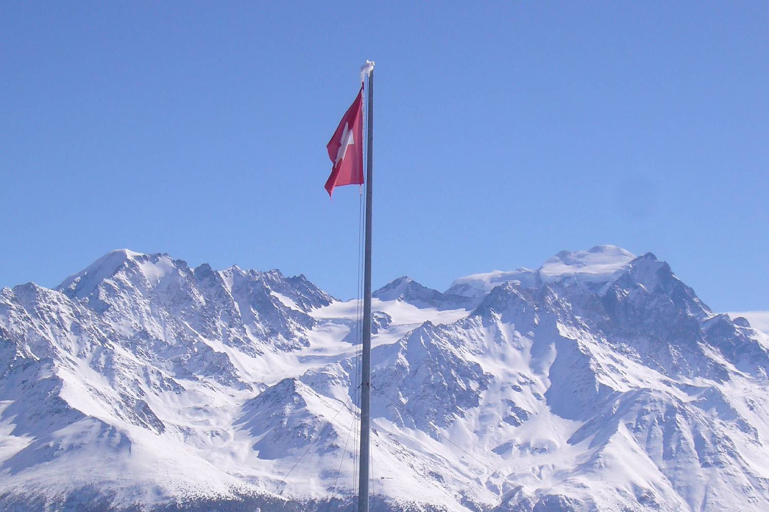 Schweizer Fahne in verschneiten Bergen
