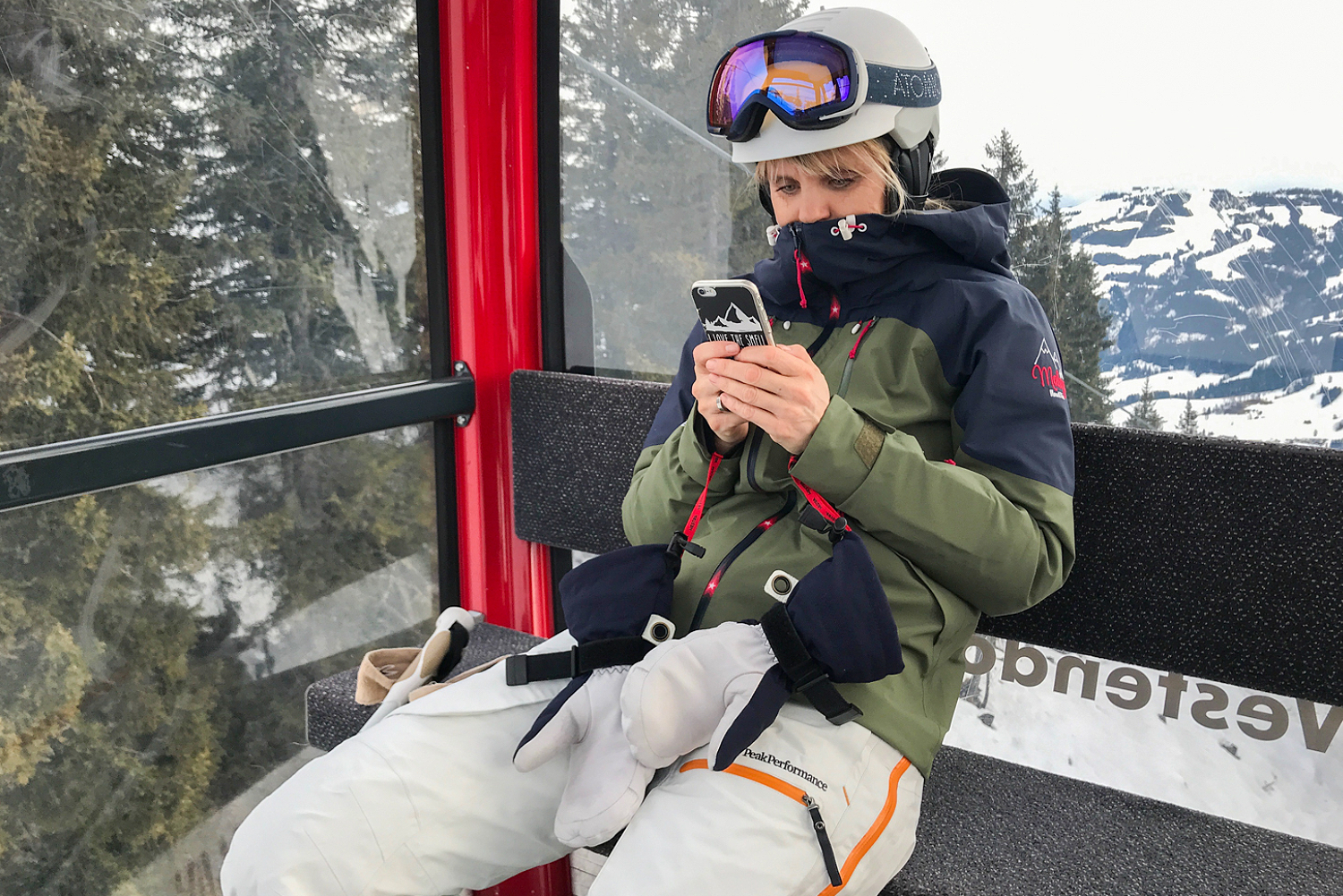Skifahrerin mit Handy in Gondel 
